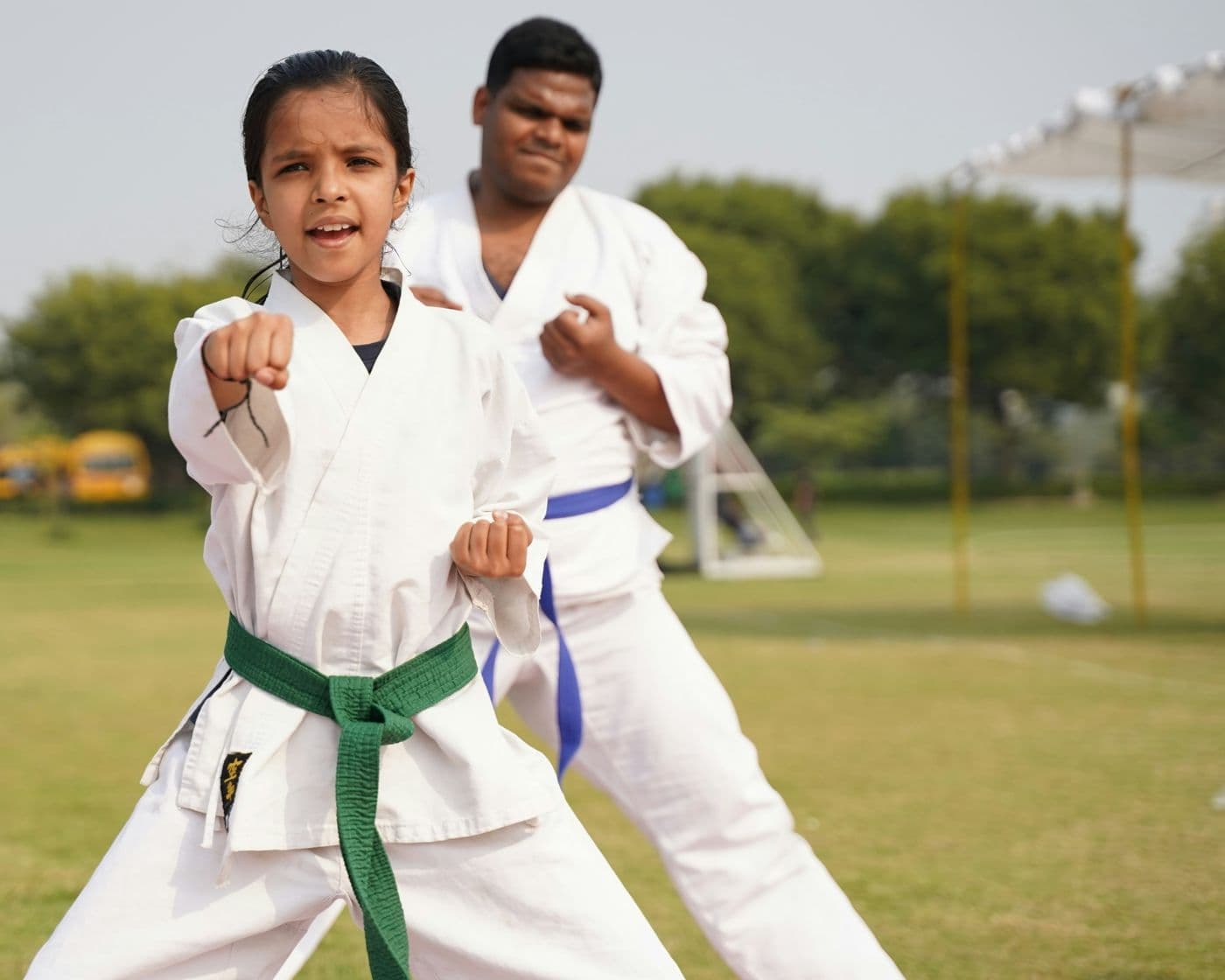 A karate instructor leading a young student outdoors